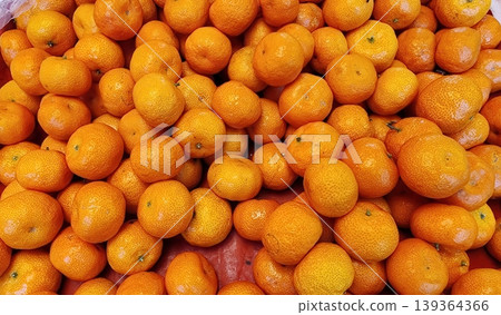Pile of Fresh Organic Mandarins in Market Stall - Healthy Citrus Fruit Background Pile of Fresh Organic Mandarins in Market Stall - Healthy Citrus Fruit Background 139364366