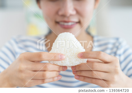 年輕女子吃飯糰 139364720
