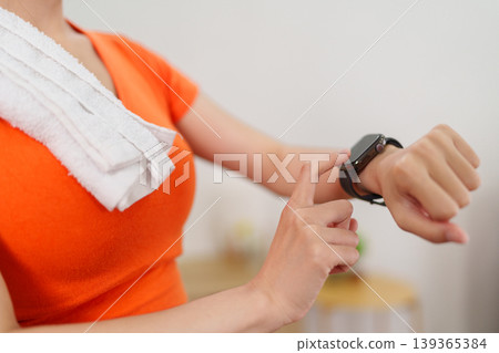 Asian women using smartwatch fitness tracker checking health data activity monitor wearable technology device smart watch sport exercise workout home wellness 139365384