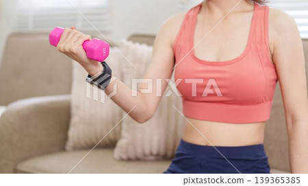 Asian women lifting pink dumbbell weight training exercise workout fitness at home living room wearing sport bra sportswear healthy lifestyle wellness routine Asian women lifting pink dumbbell weight training exercise workout fitness at home living room wearing sport bra sportswear healthy lifestyle wellness routine 139365385