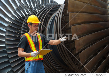 Asian Male Technician 30-40s Inspecting Turbine Blades at a Power Plant Asian Male Technician 30-40s Inspecting Turbine Blades at a Power Plant 139365596