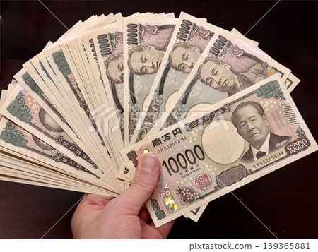Holding a 10,000 yen bill in my hand Holding a 10,000 yen bill in my hand 139365881