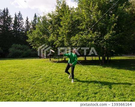 Woman playing badminton with racket in green city park. Active lady having fun during outdoor sport leisure activity. Healthy lifestyle and recreation concept in nature on summer day. Woman playing badminton with racket in green city park. Active lady having fun during outdoor sport leisure activity. Healthy lifestyle and recreation concept in nature on summer day. 139366164
