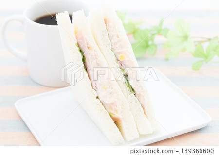 A delicious ham, tuna, and lettuce sandwich and coffee for breakfast. A delicious ham, tuna, and lettuce sandwich and coffee for breakfast. 139366600