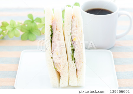 A delicious ham, tuna, and lettuce sandwich and coffee for breakfast. A delicious ham, tuna, and lettuce sandwich and coffee for breakfast. 139366601