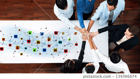 Collaborative Teamwork Around a Table with Digital Connections Representing Networking and Communication in a Modern Workspace Environment Trope Collaborative Teamwork Around a Table with Digital Connections Representing Networking and Communication in a Modern Workspace Environment Trope 139366874
