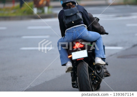 一張女子與另一人同乘坐摩托車的圖片。 一張女子與另一人同乘坐摩托車的圖片。 139367114