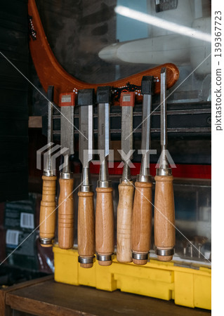 Woodworking equipment. Carpentry hand tool. Carving chisels set with sharp steel blades hanging in joinery organizer storage case. Woodworking equipment. Carpentry hand tool. Carving chisels set with sharp steel blades hanging in joinery organizer storage case. 139367723