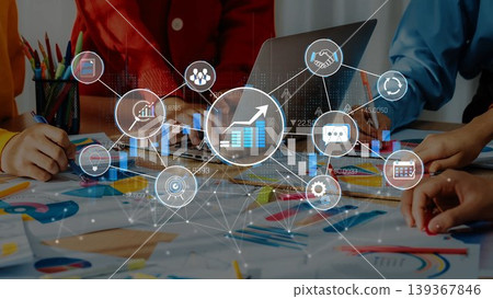 A dynamic business meeting scene showcasing teamwork and data visualization. Hands engage with charts and growth icons, highlighting innovation and strategy in a modern office environment. Sigmoid A dynamic business meeting scene showcasing teamwork and data visualization. Hands engage with charts and growth icons, highlighting innovation and strategy in a modern office environment. Sigmoid 139367846