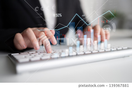 Business professional analyzing financial data with charts and graphs, managing stock market trends and performance metrics on a keyboard in a modern office Scalp 139367881