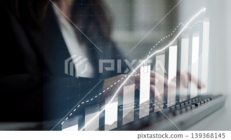 Business professional analyzing data trends with keyboard in foreground and upward growth graph overlay representing financial success and progress. Copula Business professional analyzing data trends with keyboard in foreground and upward growth graph overlay representing financial success and progress. Copula 139368145
