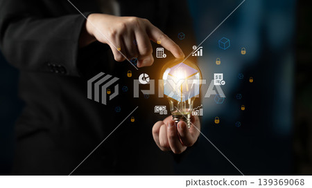 Business innovation concept with a glowing light bulb in hand, showcasing digital icons representing ideas, creativity, and technology for future growth Cyphers. Business innovation concept with a glowing light bulb in hand, showcasing digital icons representing ideas, creativity, and technology for future growth Cyphers. 139369068