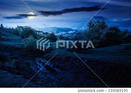 carpathian mountain landscape on a foggy night. outdoor adventure with stunning view. full moon over countryside landscape with rolling hills, fog and cloudy sky. mysterious fantasy carpathian mountain landscape on a foggy night. outdoor adventure with stunning view. full moon over countryside landscape with rolling hills, fog and cloudy sky. mysterious fantasy 139369195