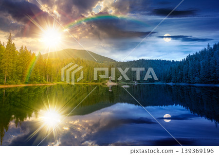 day meet night. landscape by the lake. coniferous forest near the lake and the forest mountain. epic summer solstice view of carpathian mountain reflection on synevr lake surface. harmony concept 139369196