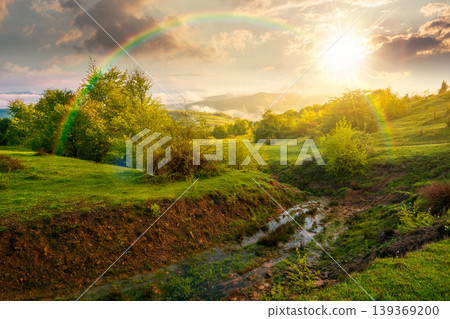 foggy sunset over carpathian mountain landscape. outdoor adventure with stunning view in evening light. countryside landscape with rolling hills, fog and cloudy sky. weather with rainbow 139369200