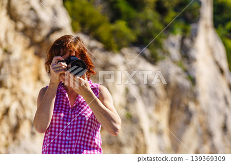 Mature woman take travel photo in mountain nature Mature woman take travel photo in mountain nature 139369309