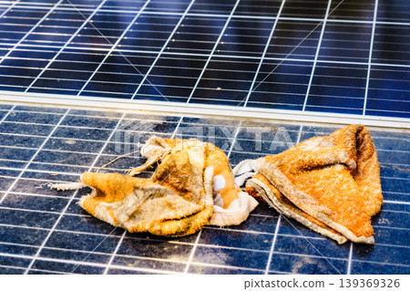 Cleaning tools are placed on solar panels as part of maintenance work during the day at a renewable energy site in a sunny location Cleaning tools are placed on solar panels as part of maintenance work during the day at a renewable energy site in a sunny location 139369326