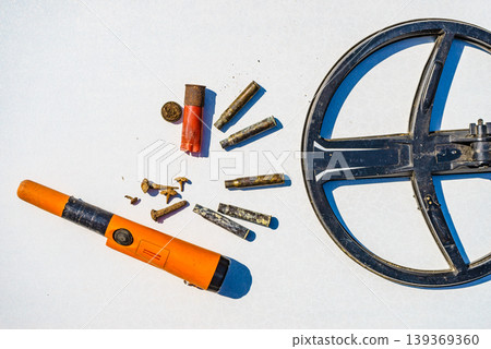 Metal detecting equipment gear and found items displayed on a white surface. Hobby and activity Metal detecting equipment gear and found items displayed on a white surface. Hobby and activity 139369360