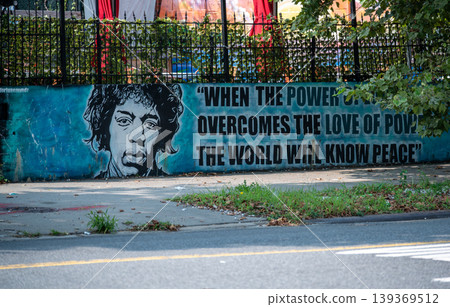 New york, usa august 16,2024. Jimi hendrix portrait and peace quote painted on distressed blue wall in nyc, urban street art reflecting hope, unity and cultural legacy New york, usa august 16,2024. Jimi hendrix portrait and peace quote painted on distressed blue wall in nyc, urban street art reflecting hope, unity and cultural legacy 139369512
