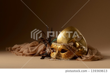 Golden Venetian carnival masks on a beige background. Golden Venetian carnival masks on a beige background. 139369613