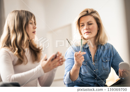 Woman applying makeup, focusing on daily beauty routine Woman applying makeup, focusing on daily beauty routine 139369700