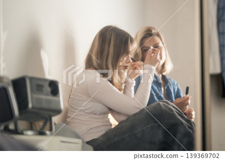 Young woman learning makeup with adult guidance 139369702