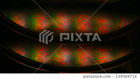 Oil fluid. Gasoline leak. Defocused green orange purple color round bubble liquid paint blend wave floating on abstract art dark black background Oil fluid. Gasoline leak. Defocused green orange purple color round bubble liquid paint blend wave floating on abstract art dark black background 139369718