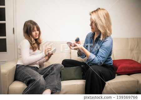 Mother and daughter applying makeup bonding together at home Mother and daughter applying makeup bonding together at home 139369766