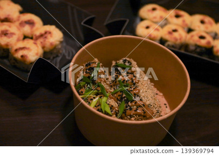 Crispy fried rolls with sauce and sesame seeds in bowl, savory baked sushi on dark table 139369794