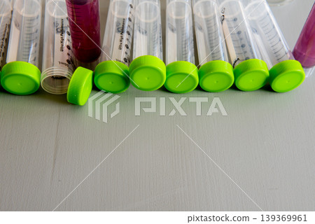 laboratory test tubes with green caps and sample liquids on table laboratory test tubes with green caps and sample liquids on table 139369961