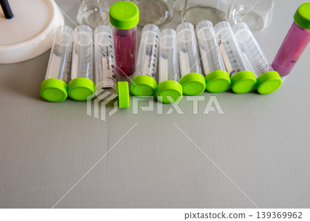 laboratory test tubes with green caps and sample liquids on table laboratory test tubes with green caps and sample liquids on table 139369962