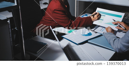 business people or accountant using calculator while working analytical business report on the workplace, accounting concept, Serious and focused financier accountant on paper work inside office, 139370013