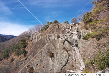 Iwadono-yama and Chigo-otoshi cliffs. A spectacular view of towering, sheer rock faces and historical remains associated with the Takeda clan in Otsuki City, Yamanashi Prefecture. Iwadono-yama and Chigo-otoshi cliffs. A spectacular view of towering, sheer rock faces and historical remains associated with the Takeda clan in Otsuki City, Yamanashi Prefecture. 139370186