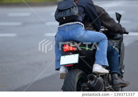 一張女子與另一人同乘坐摩托車的圖片。 一張女子與另一人同乘坐摩托車的圖片。 139371337