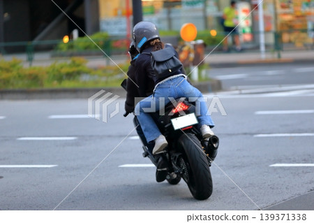 一張女子與另一人同乘坐摩托車的圖片。 一張女子與另一人同乘坐摩托車的圖片。 139371338