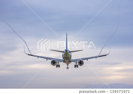 Sendai Airport at dusk: A plane landing and its vapor trail. Natori City, Miyagi Prefecture. 139371972