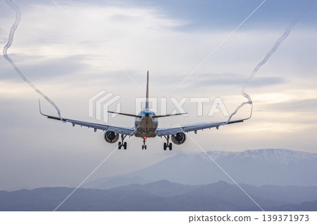 黃昏時的仙台機場:一架飛機正在降落,拖著長長的尾跡。宮城縣名取市。 黃昏時的仙台機場:一架飛機正在降落,拖著長長的尾跡。宮城縣名取市。 139371973