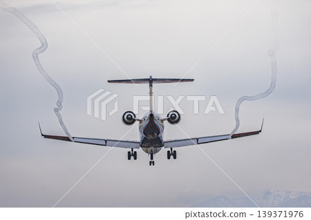 黃昏時的仙台機場：一架飛機正在降落，拖著長長的尾跡。宮城縣名取市。 139371976