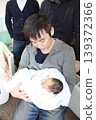 A father is holding his two-day-old baby in a private maternity room. 139372366