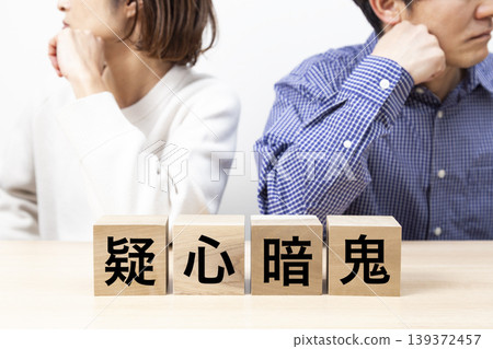 A couple arguing over a block that reads "Suspicion and Distrust" A couple arguing over a block that reads "Suspicion and Distrust" 139372457