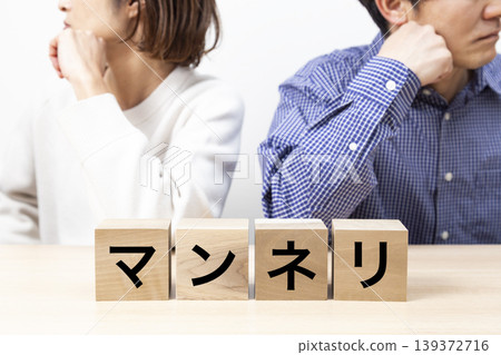A couple arguing over a block that says "monotony." 139372716