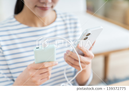 一位年輕女子帶著便攜式電池 一位年輕女子帶著便攜式電池 139372775