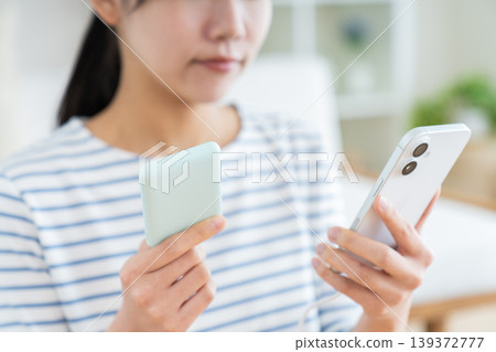 一位年輕女子帶著便攜式電池 一位年輕女子帶著便攜式電池 139372777