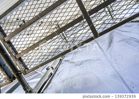 A view looking up at the new exterior walls and scaffolding of a detached house. A view looking up at the new exterior walls and scaffolding of a detached house. 139372939