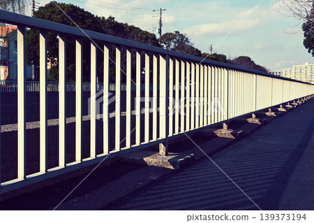 Fence on the sidewalk along the irrigation canal 139373194