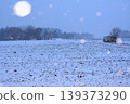 一輛汽車停在白雪皚皚的田野裡，背景是冬日的景色。 139373290