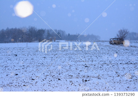A vehicle standing in a snow-covered field, against a winter backdrop. A vehicle standing in a snow-covered field, against a winter backdrop. 139373290