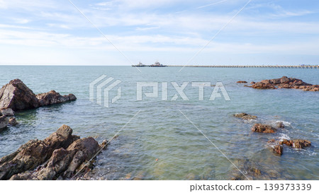 Jagged Rock Formations in Sea with Ships on the Horizon Jagged Rock Formations in Sea with Ships on the Horizon 139373339