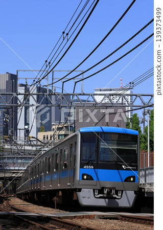 Odakyu Line 4000 series train running with the cluster of buildings near Shinjuku in the background. Odakyu Line 4000 series train running with the cluster of buildings near Shinjuku in the background. 139373499