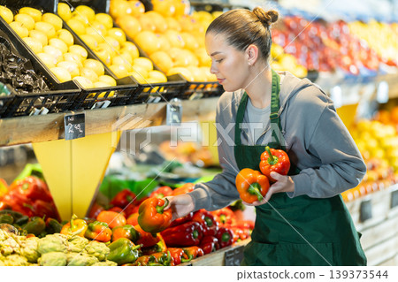 seller lays out red bell peppers in the window seller lays out red bell peppers in the window 139373544